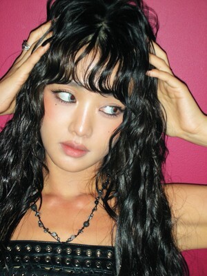 민니, 짙은 분홍 배경 속 블랙 가죽 스트랩 탑과 젖은 듯 윤기 나는 흑발… 묘한 시선 처리로 눈길 사로잡는 모습 (+패션, 스타일, 매력)